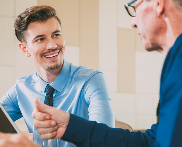 Smiling Businessman Listening to Senior Man