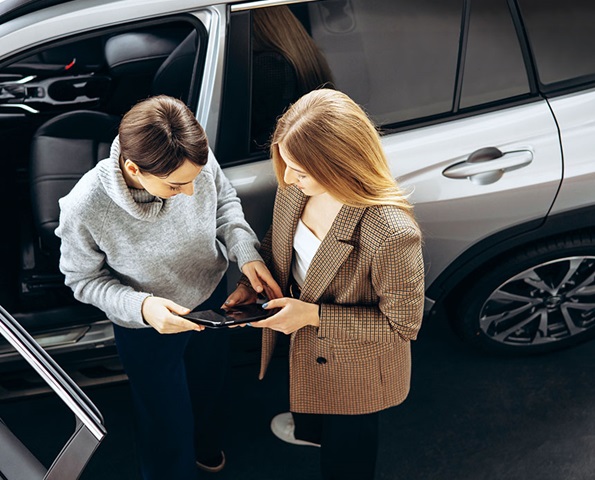 Two-women-conversing-near-a-parked-car