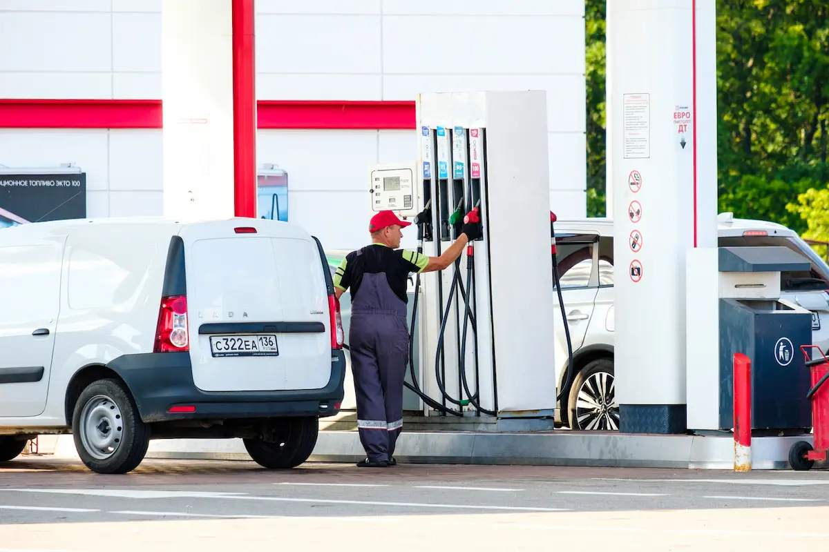 Person refuelling a vehicle at a petrol station.