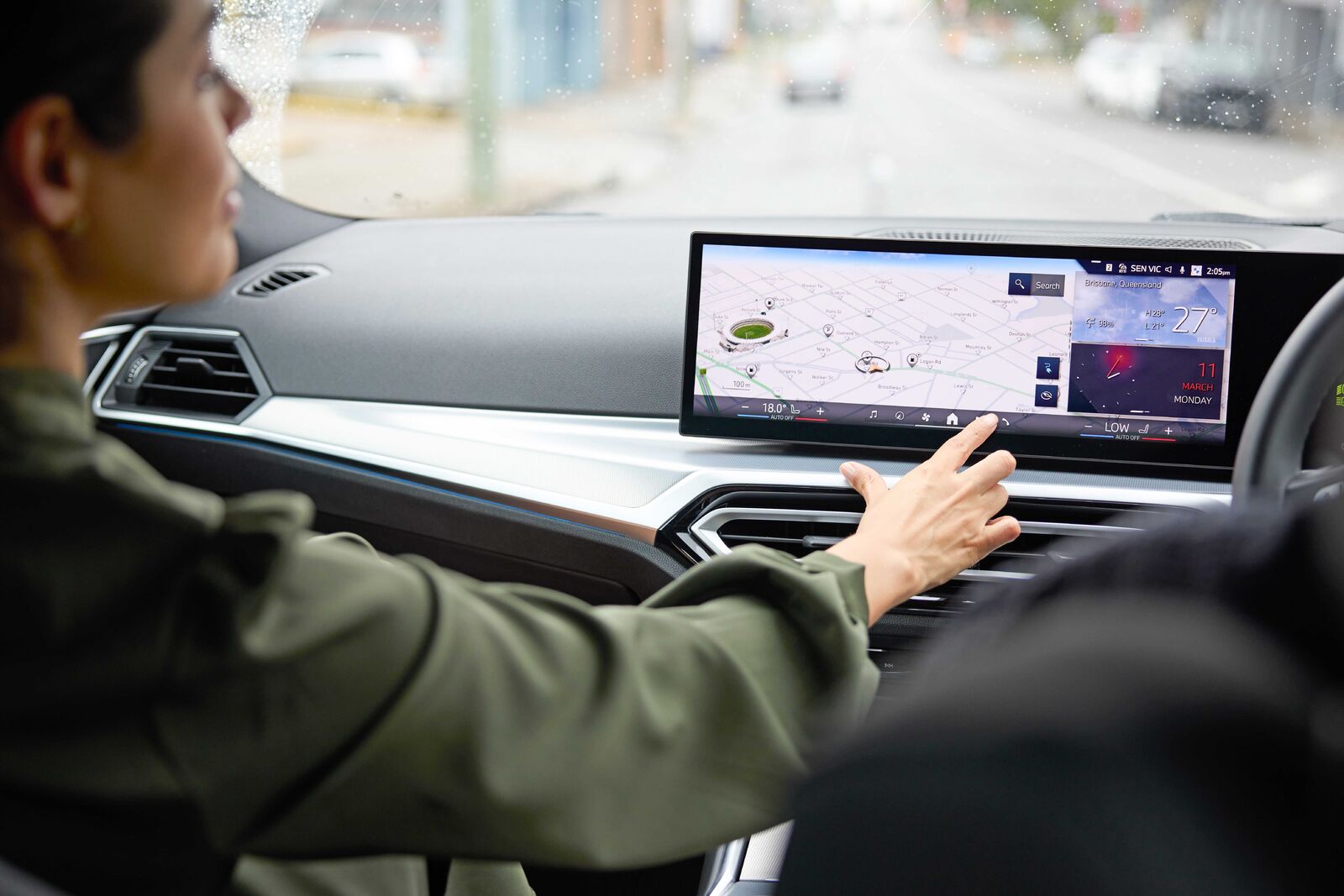 Driver using a car's touchscreen display with navigation and vehicle data, illustrating modern fleet technology.