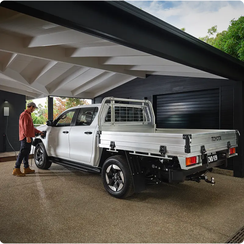 Toyota pickup charging under modern home carport