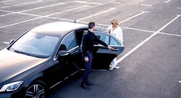 Person opening a vehicle door for someone else