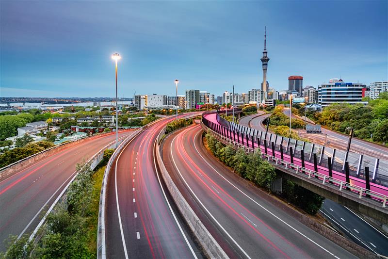 Auckland city with the Skytower in the background and state highway one and bike lane in the foreground