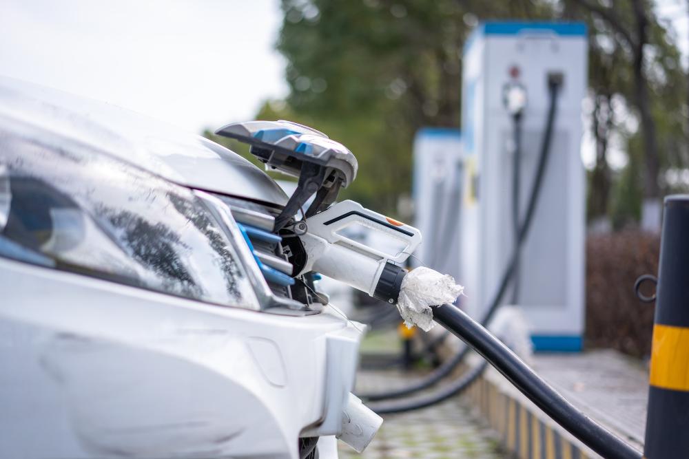 Does salary sacrifice remove the need to submit a P11D Does salary sacrifice remove the need to submit a P11D: A close-up of a white electric car plugged in and charging at a row of public charging points, with the charging cable connected to the front of the vehicle.