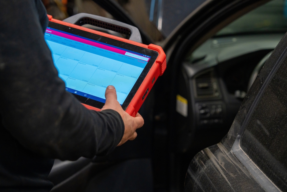Improving driver communication in fleets: Technician inside a vehicle using a rugged tablet device to access or update fleet or vehicle data.
